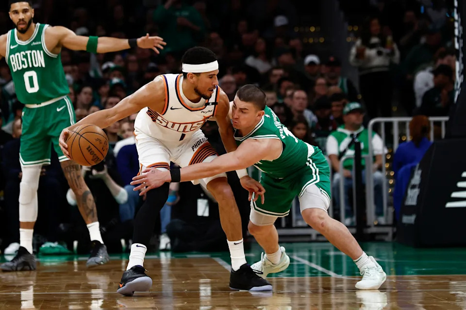 Apr 4, 2025; Boston, Massachusetts, USA; Boston Celtics guard Payton Pritchard (11) tries to knock the ball away from Phoenix Suns guard Devin Booker (1) during the first quarter at TD Garden. Mandatory Credit: Winslow Townson-Imagn Images