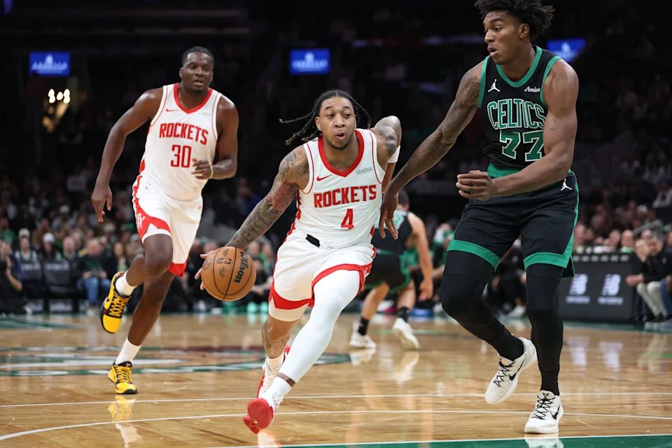 Nov 1, 2025; Boston, Massachusetts, USA; Houston Rockets guard JD Davison (4) drives to the basket defended by Boston Celtics center Amari Williams (77) during the second half at TD Garden. Mandatory Credit: Paul Rutherford-Imagn Images