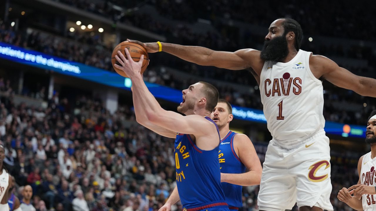 Cleveland Cavaliers guard James Harden, right, goes up to block a shot by Denver Nuggets guard Christian Braun in the first half of an NBA basketball game Monday, Feb. 9, 2026, in Denver. (AP Photo/David Zalubowski)