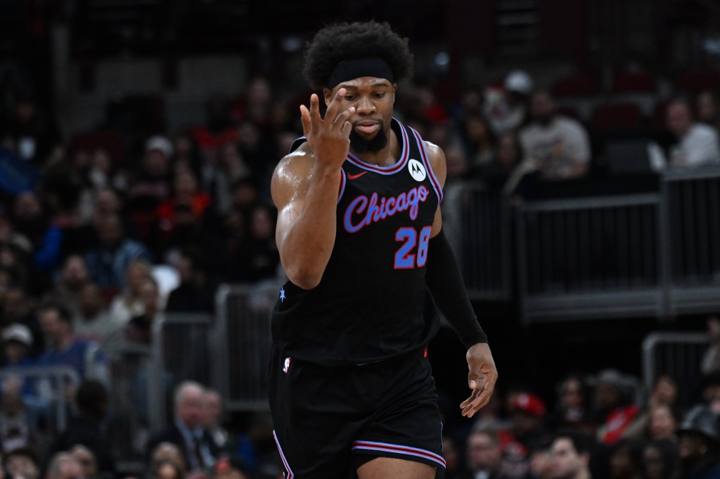 Guerschon Yabusele in a black jersey with "Chicago" and number 28, holding up three fingers after scoring a three-point basket.