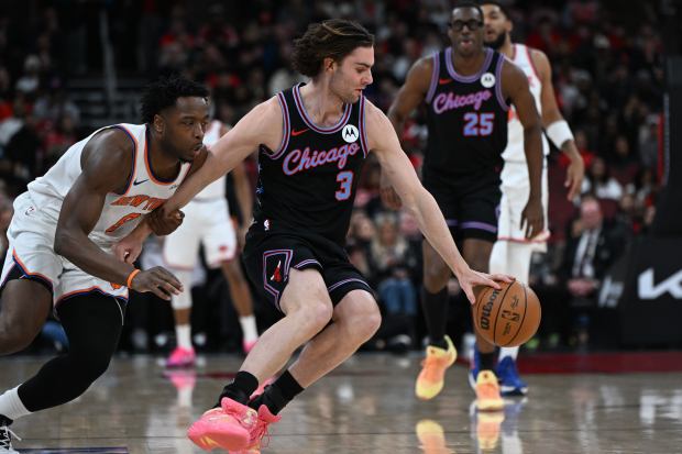 New York Knicks' OG Anunoby battles Chicago Bulls' Josh Giddey for a loose ball during the first half on Sunday, Feb. 22, 2026, in Chicago. (AP Photo/Paul Beaty)