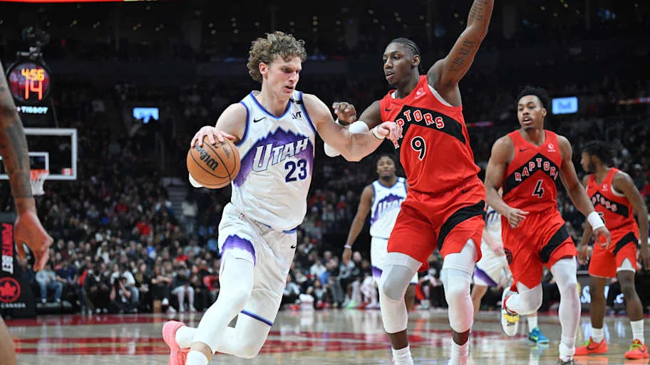 Utah Jazz forward Lauri Markkanen dribbles the ball as Toronto Raptors forward RJ Barrett defends