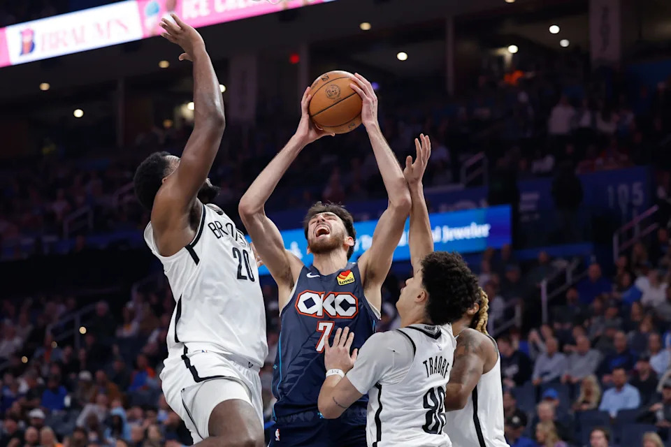Feb 20, 2026; Oklahoma City, Oklahoma, USA; Oklahoma City Thunder center/forward Chet Holmgren (7) goes up for a basket between Brooklyn Nets center Day'ron Sharpe (20) and guard Nolan Traore (88) during the second half at Paycom Center. Mandatory Credit: Alonzo Adams-Imagn Images
