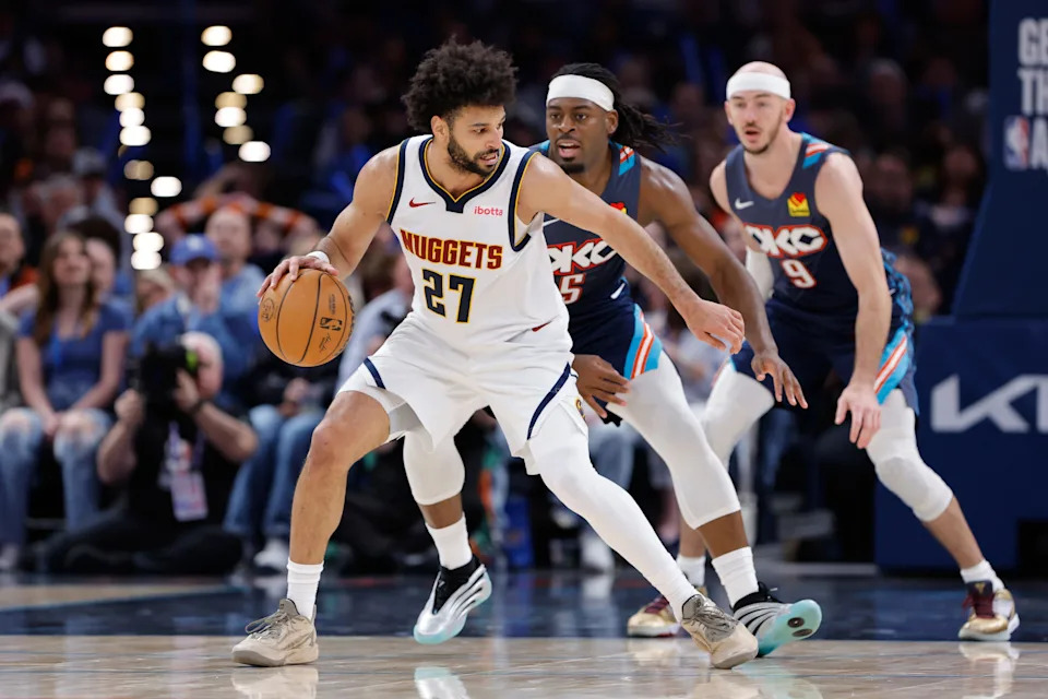 Feb 27, 2026; Oklahoma City, Oklahoma, USA; Denver Nuggets guard Jamal Murray (27) moves the ball around Oklahoma City Thunder guard Luguentz Dort (5) during the third quarter at Paycom Center. Mandatory Credit: Alonzo Adams-Imagn Images