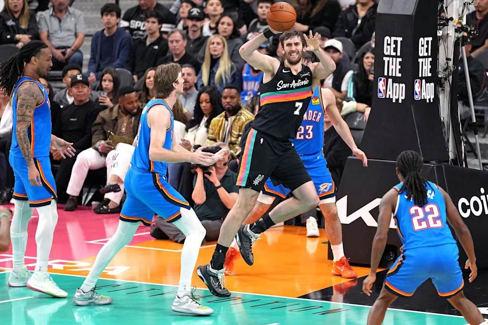 Feb 4, 2026; San Antonio, Texas, USA; San Antonio Spurs center Luke Kornet (7) saves the ball from going out of bounds ahead of Oklahoma City Thunder center Branden Carlson (15) and forward Jaylin Williams (6) during the second half at Frost Bank Center. Mandatory Credit: Scott Wachter-Imagn Images