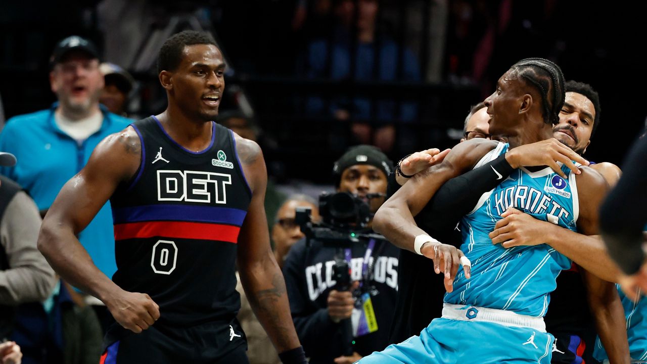 Charlotte Hornets forward Moussa Diabaté, front right, is held back as he fights Detroit Pistons center Jalen Duren (0) on the court in the second half of an NBA basketball game in Charlotte, N.C., on Monday, Feb. 9, 2026. (AP Photo/Nell Redmond)
