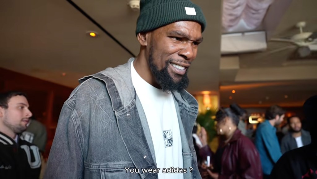 NBA star Kevin Durant grimaces in a green beanie and denim jacket.