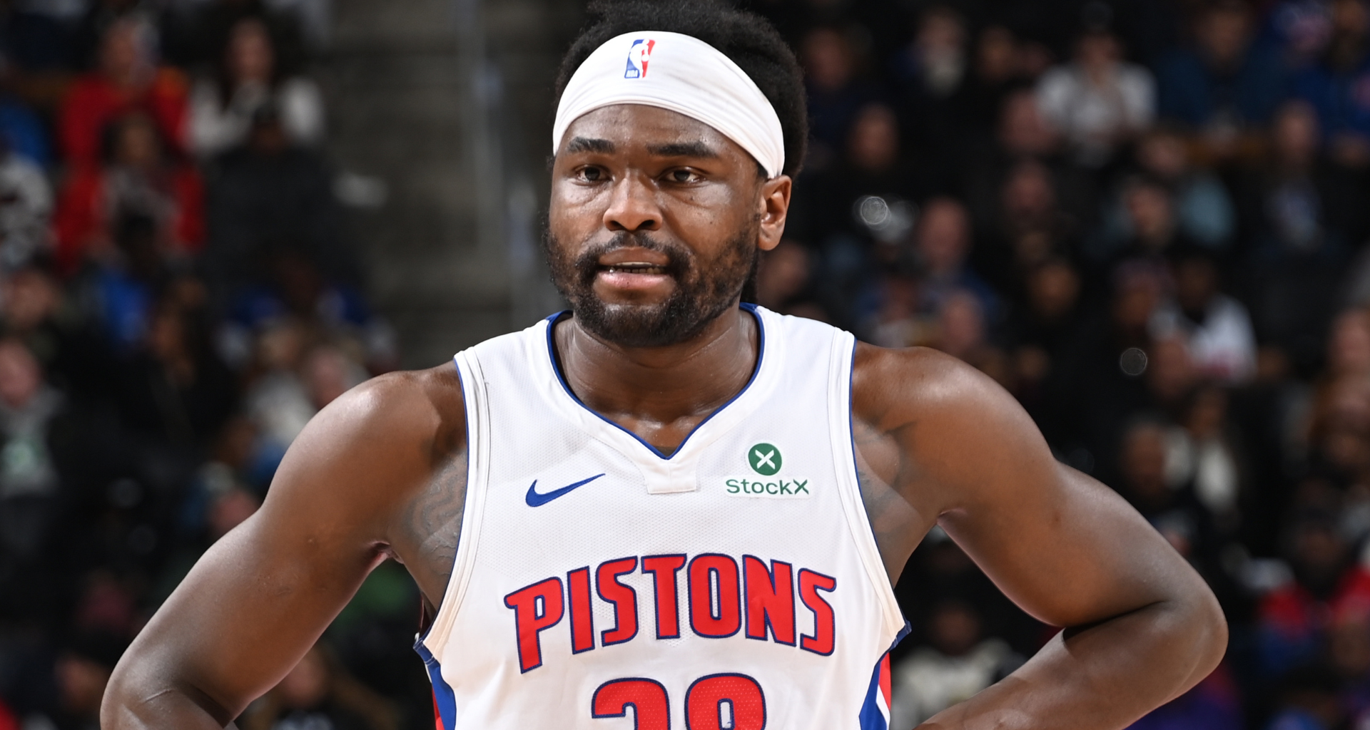 Isaiah Stewart wearing a Detroit Pistons jersey, number 28, with a headband, standing on the court.