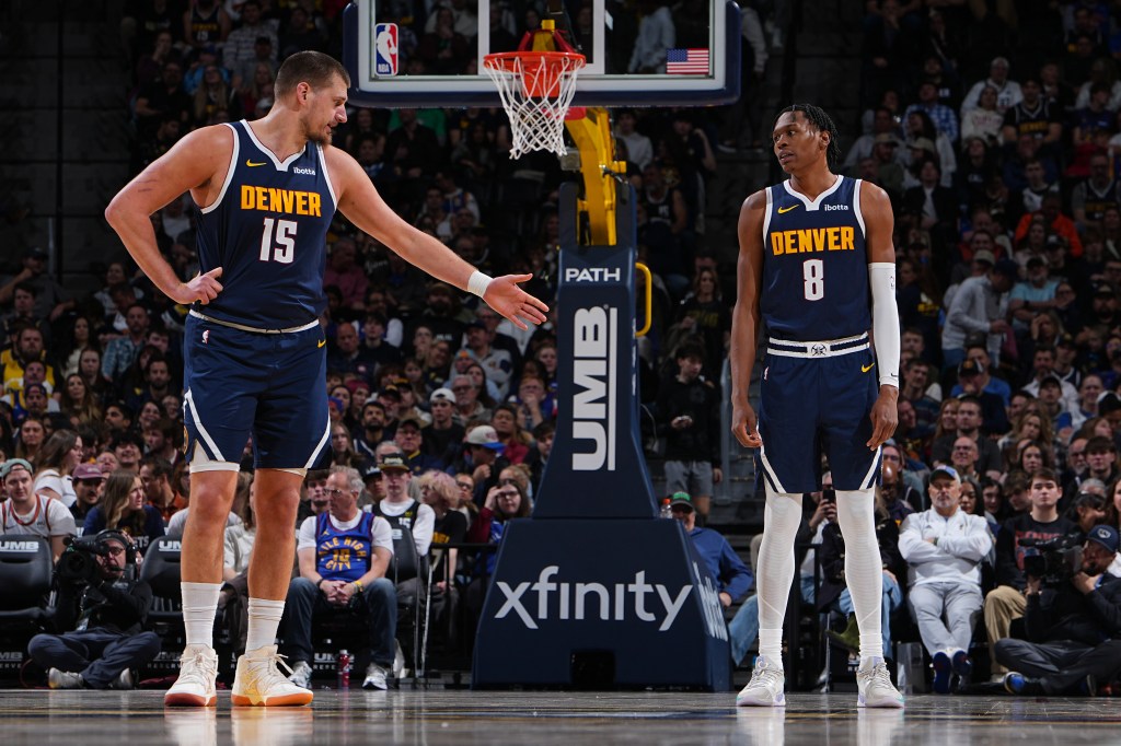 Nikola Jokic #15 and Peyton Watson #8 of the Denver Nuggets looks on during the game.