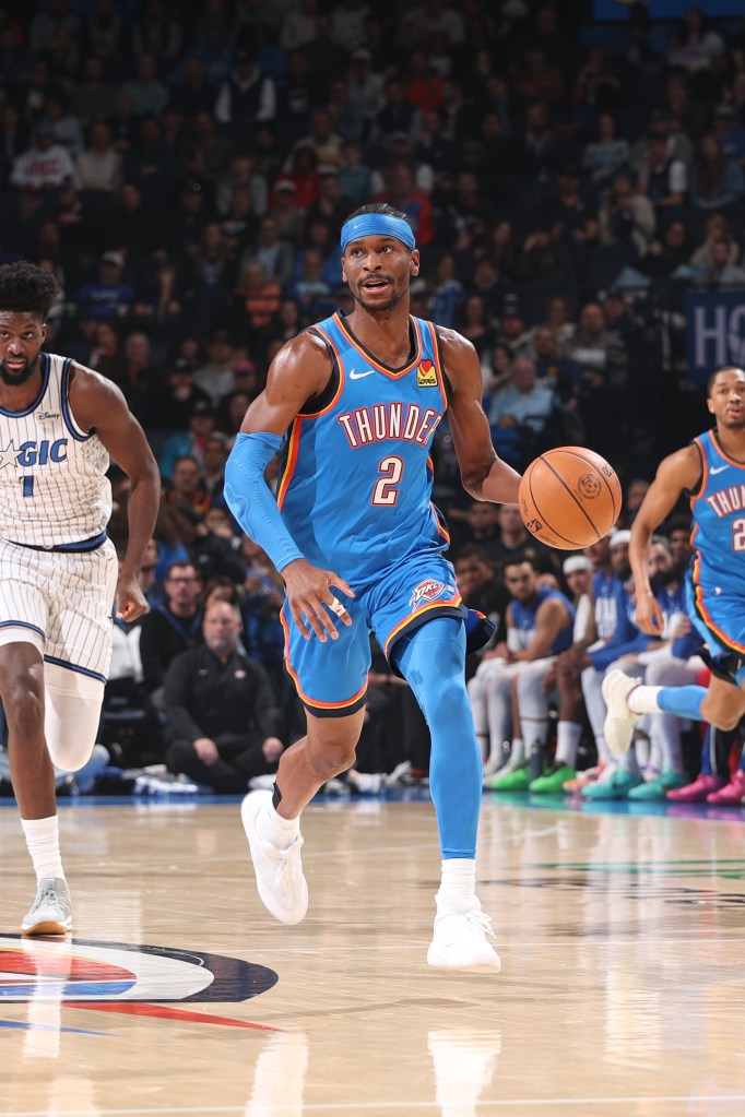 Oklahoma City Thunder player Shai Gilgeous-Alexander dribbles the ball during a game against the Orlando Magic.