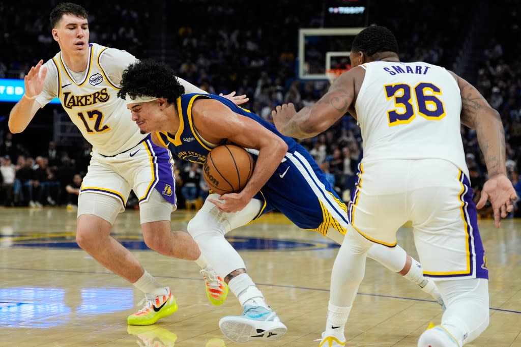 Golden State Warriors forward Gui Santos, center, moves the ball between Los Angeles Lakers forward Jake LaRavia (12) and guard Marcus Smart (36) during the second half of an NBA basketball game, Saturday, Feb. 28, 2026, in San Francisco. (AP Photo/Godofredo A. Vásquez) AP