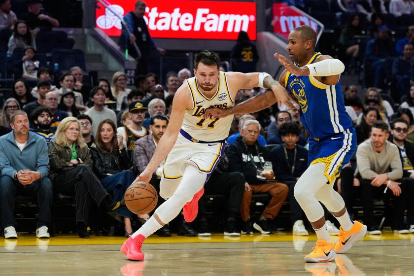 Los Angeles Lakers guard Luka Doncic (77) moves the ball while defended.