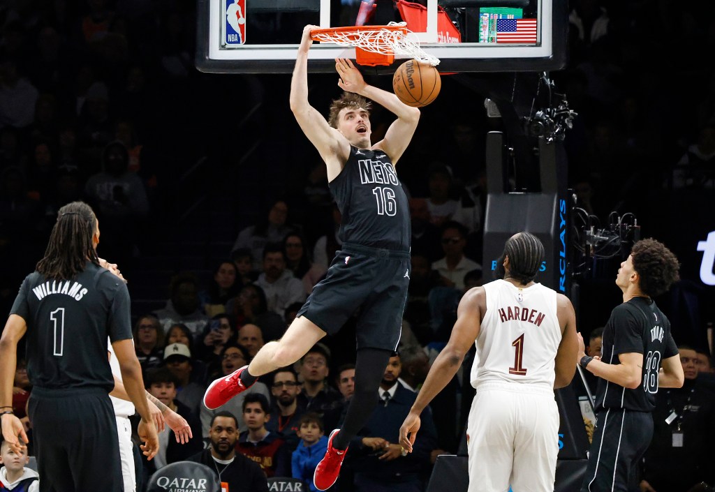 Brooklyn Nets' Grant Nelson slams the ball as Cleveland Cavaliers' James Harden watches.