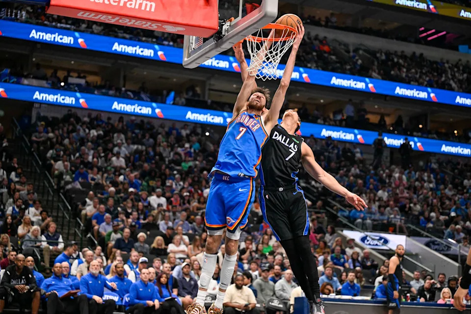 Mar 1, 2026; Dallas, Texas, USA; Oklahoma City Thunder center Chet Holmgren (7) dunks the ball past Dallas Mavericks forward Dwight Powell (7) during the second half at the American Airlines Center. Mandatory Credit: Jerome Miron-Imagn Images