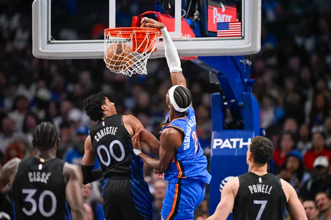 Mar 1, 2026; Dallas, Texas, USA; Oklahoma City Thunder guard Shai Gilgeous-Alexander (2) dunks the ball over Dallas Mavericks guard Max Christie (00) during the second quarter at the American Airlines Center. Mandatory Credit: Jerome Miron-Imagn Images