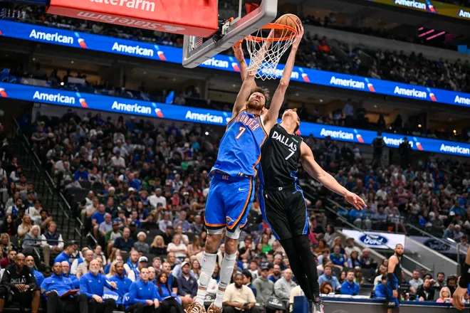 Mar 1, 2026; Dallas, Texas, USA; Oklahoma City Thunder center Chet Holmgren (7) dunks the ball past Dallas Mavericks forward Dwight Powell (7) during the second half at the American Airlines Center. Mandatory Credit: Jerome Miron-Imagn Images