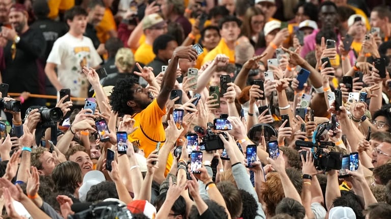 Arizona State guard Maurice Odum celebrates with fans after defeating...