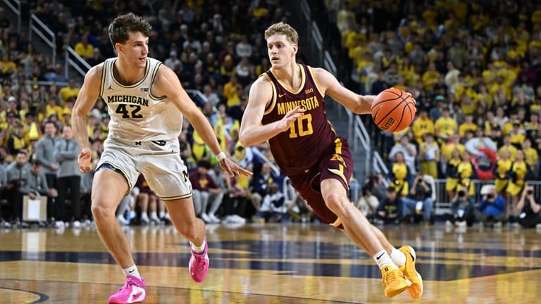 Minnesota forward Cade Tyson (10) drives past Michigan forward Will...