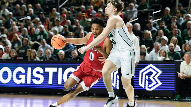 Miami (Ohio) wing Eian Elmer (0) drives past Ohio forward...