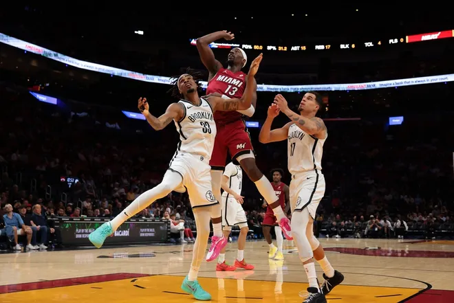 Mar 5, 2026; Miami, Florida, USA; Miami Heat center Bam Adebayo (13) shoots the basketball against Brooklyn Nets center Nic Claxton (33) and forward Michael Porter Jr. (17) during the third quarter at Kaseya Center.