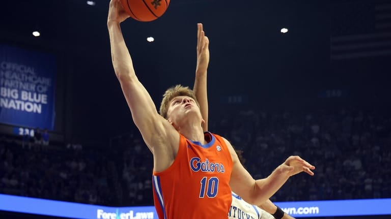 Florida's Thomas Haugh (10) pulls in a rebound in front...