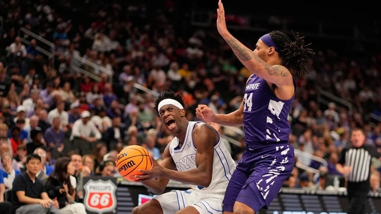 BYU forward AJ Dybantsa, left, looks to shoot under pressure...