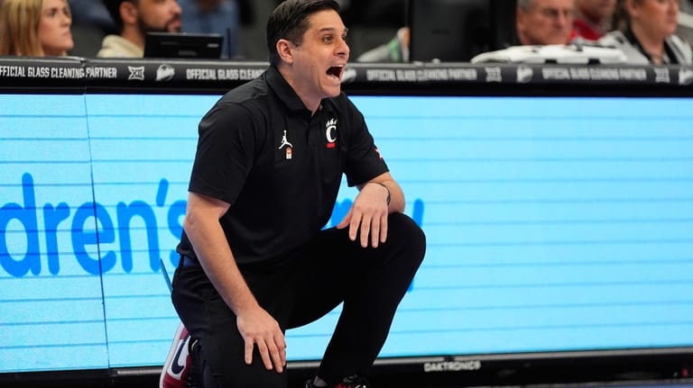 Cincinnati head coach Wes Miller talks to his players during...