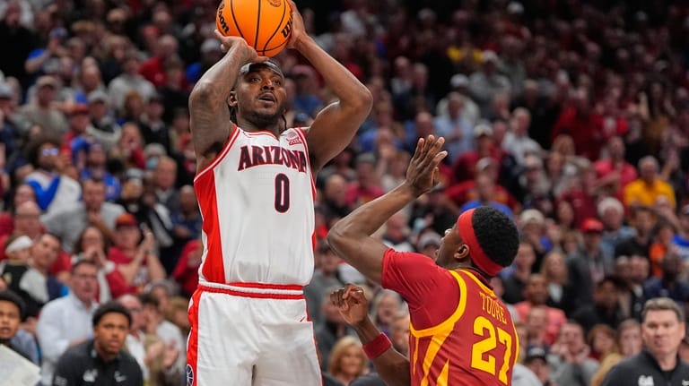Arizona's Jaden Bradley (0) makes a game-winning basket over Iowa...