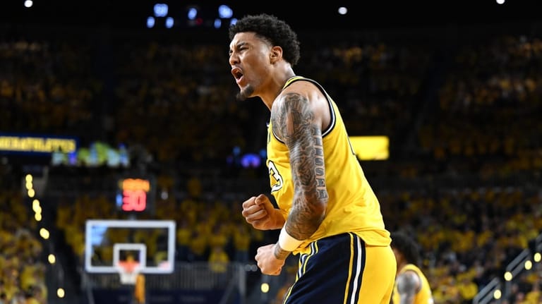Michigan forward Yaxel Lendeborg celebrates after dunking the ball against...