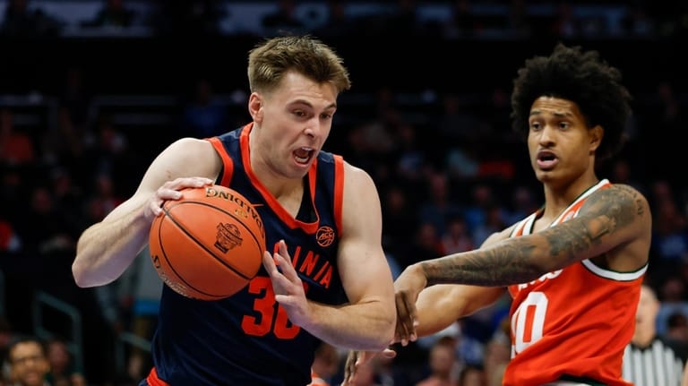 Virginia guard Dallin Hall, left, drives against Miami guard Tru...