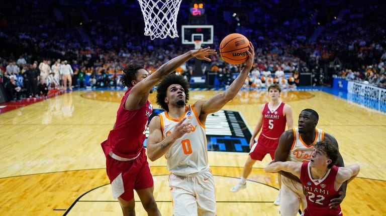 Tennessee's Ja'kobi Gillespie, right, goes up for a shot against...