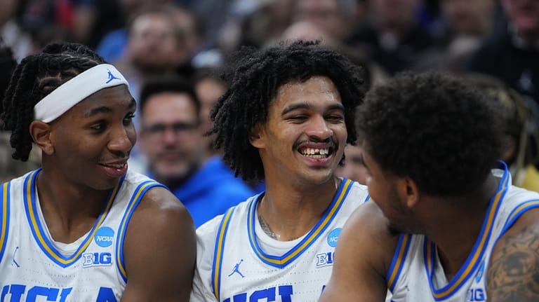 UCLA's Skyy Clark, center, smiles after chipping his tooth during...