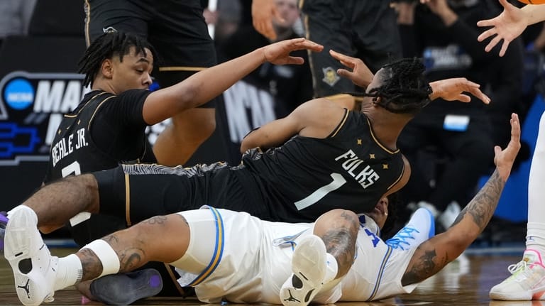 UCLA's Skyy Clark, right, has a tooth chiped by UCF's...