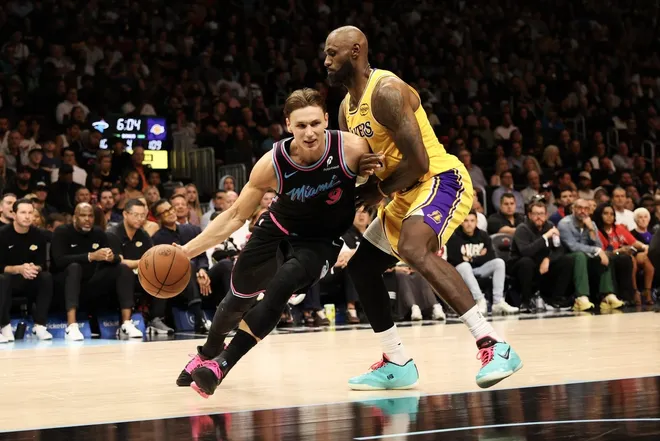 Mar 19, 2026; Miami, Florida, USA; Miami Heat guard Pelle Larsson (9) drives to basket against Los Angeles Lakers forward LeBron James (23) during second half at Kaseya Center.