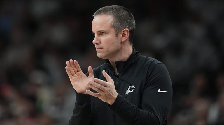 Phoenix Suns head coach Jordan Ott claps for his players...