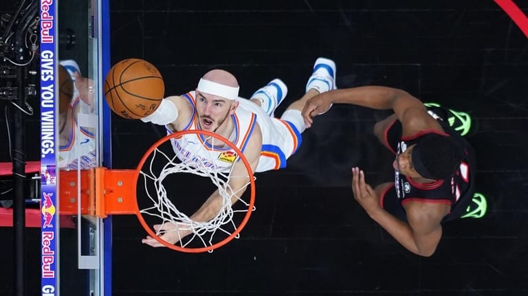 Oklahoma City Thunder's Alex Caruso, left, goes up for a...