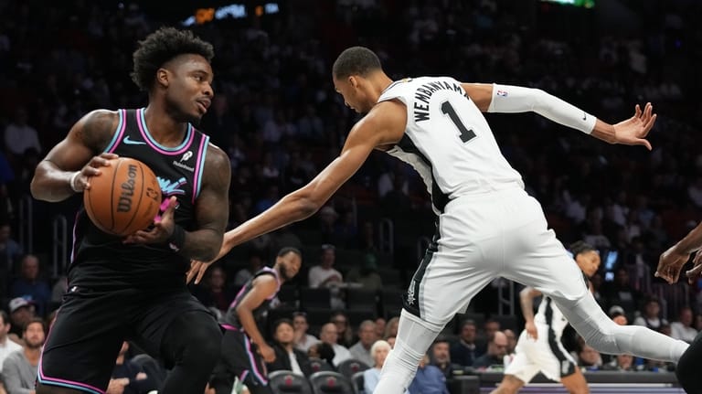 Miami Heat's Davion Mitchell, left, grabs a rebound over San...