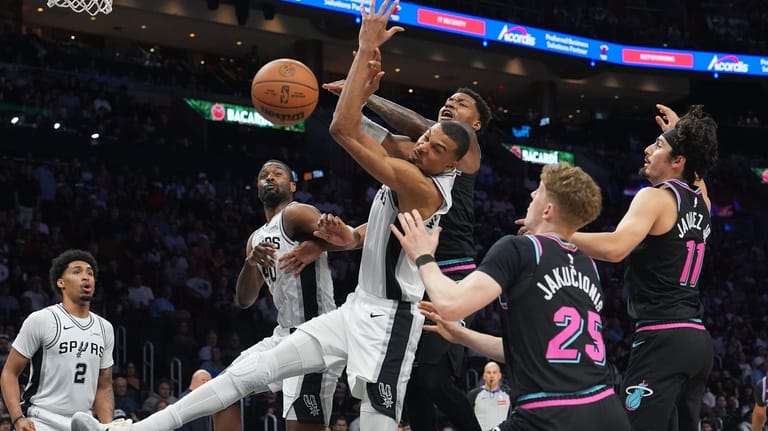 San Antonio Spurs forward Victor Wembanyama, left, front, goes for...