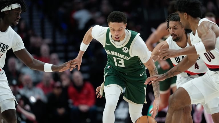 Milwaukee Bucks guard Ryan Rollins (13) goes for the ball...
