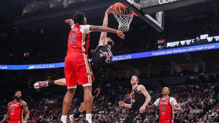 Toronto Raptors' Sandro Mamukelashvili, center right, dunks against New Orleans...