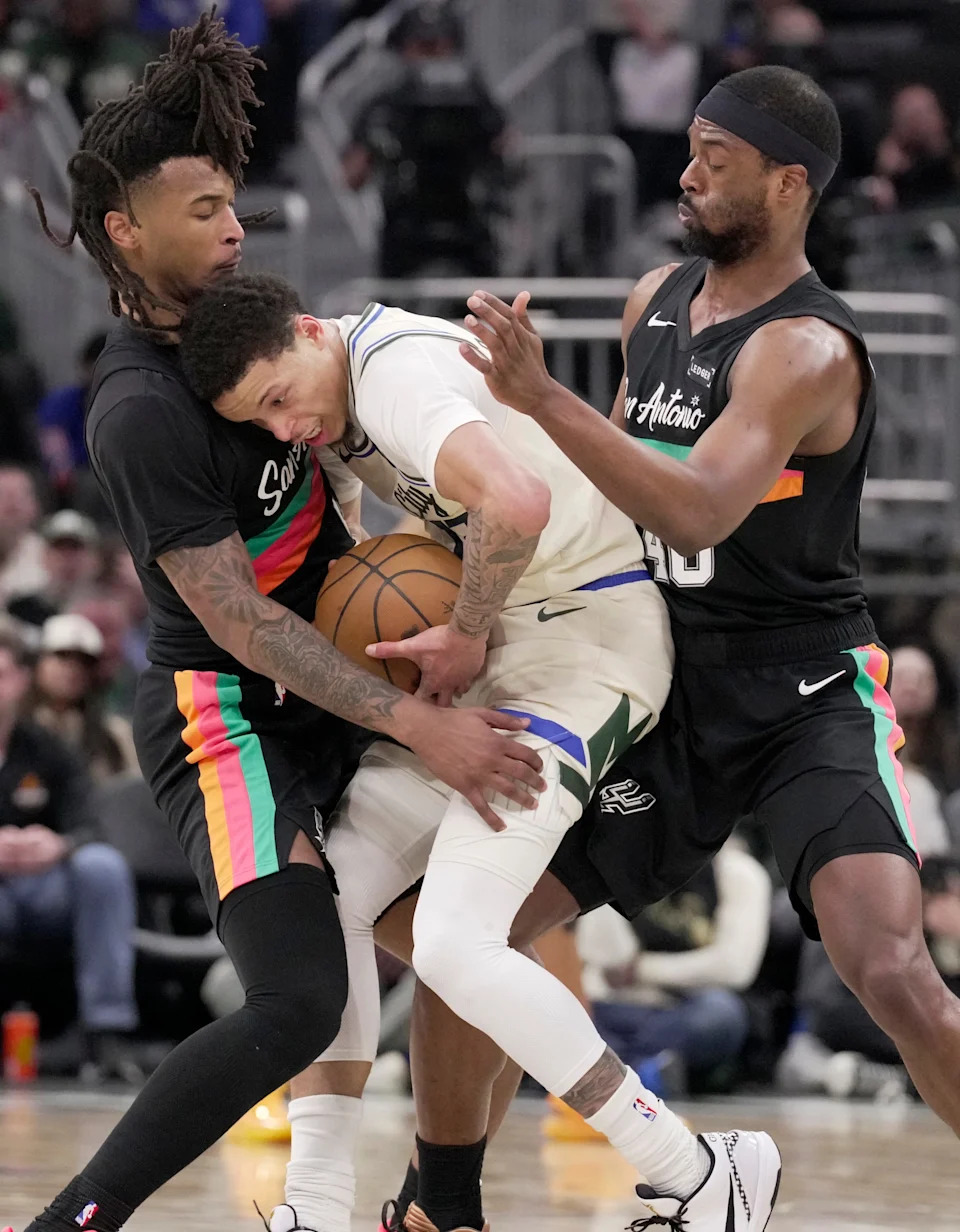 Milwaukee Bucks guard Ryan Rollins (13) is double-teamed by San Antonio Spurs guard Stephon Castle (5) and forward Harrison Barnes (40) during the first half of their game Saturday, March 28, 2026 at Fiserv Forum in Milwaukee, Wisconsin.



Mark Hoffman/Milwaukee Journal Sentinel