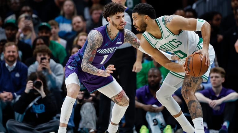 Boston Celtics forward Jayson Tatum, right, looks to drive against...
