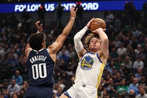 DALLAS, TEXAS - MARCH 23: Brandin Podziemski #2 of the Golden State Warriors shoots as Max Christie #00 of the Dallas Mavericks defends during the first quarter at American Airlines Center on March 23, 2026 in Dallas, Texas. NOTE TO USER: User expressly acknowledges and agrees that, by downloading and or using this photograph, user is consenting to the terms and conditions of the Getty Images License Agreement. (Photo by Sam Hodde/Getty Images)