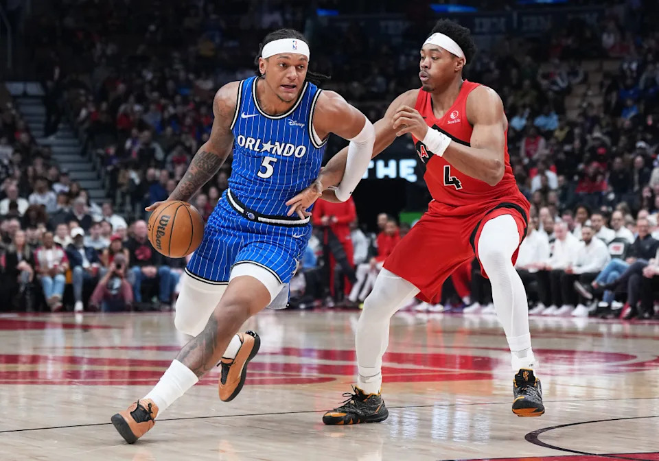 Orlando Magic forward Paolo Banchero (5) controls the ball as Toronto Raptors forward Scottie Barnes (4) tries to defend during the first quarter at Scotiabank Arena. Nick Turchiaro-Imagn Images