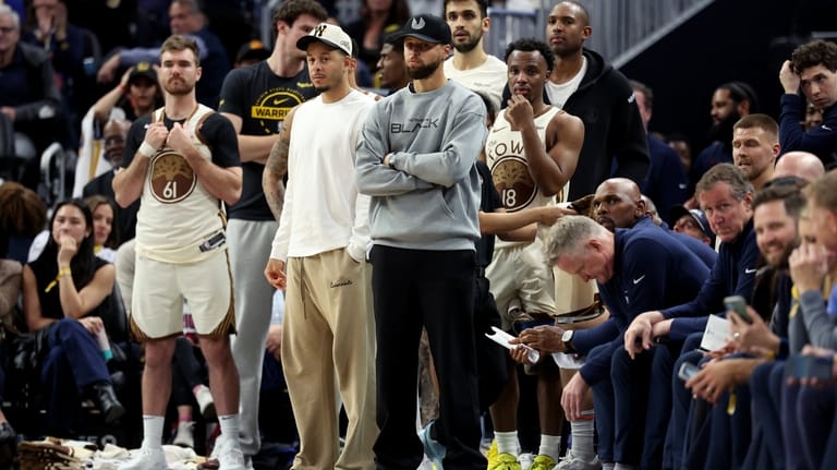 Golden State Warriors guard Stephen Curry watches from the bench...