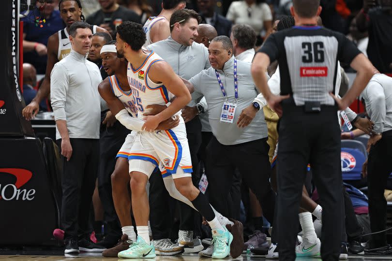 Ajay Mitchell is pulled back from a scrum of players during an NBA brawl between the OKC Thunder and Washington Wizards