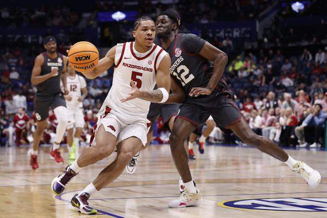 Darius Acuff Jr. of the Arkansas Razorbacks drives around Jadon Jones of the Oklahoma Sooners during the first half in the quarterfinal game of the 2026 SEC Men’s Basketball Tournament at Bridgestone Arena on Friday in Nashville, Tennessee.