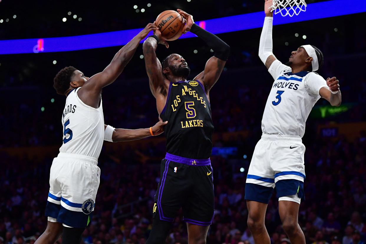 Mar 10, 2026; Los Angeles, California, USA; Los Angeles Lakers center Deandre Ayton (5) moves to the basket against Minnesota Timberwolves guard Anthony Edwards (5) and forward Jaden McDaniels (3)...