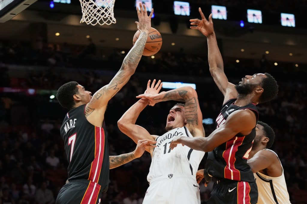 Nets forward Michael Porter Jr. gets his weak offering swatted away by Kel’el Ware (left) and Andrew Wiggins on Tuesday. AP