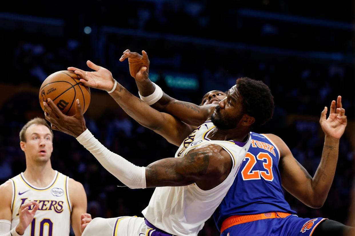 Lakers center Deandre Ayton, center, and Knicks center Mitchell Robinson battle for a rebound.